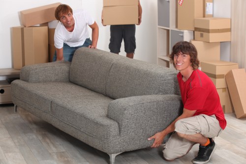 Professional movers carrying furniture in a Clapham property